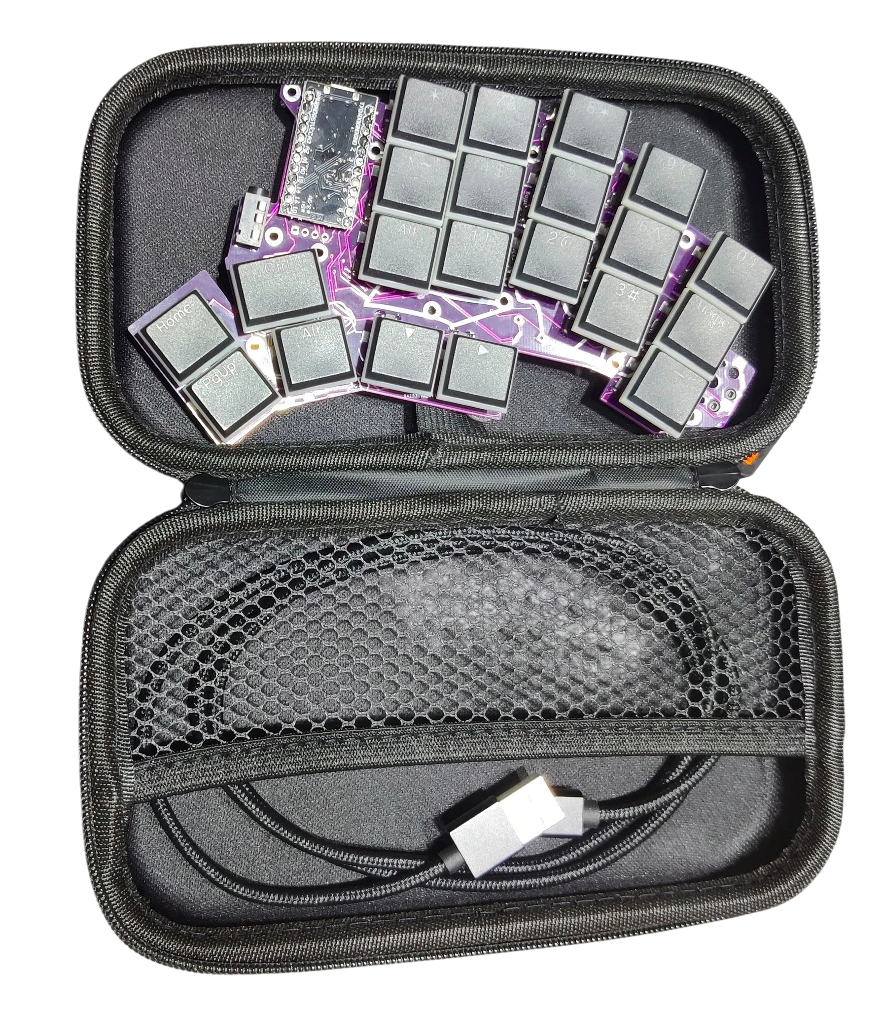 A keyboard build kit packed in its travel case, with keycaps, PCB, and USB cable
